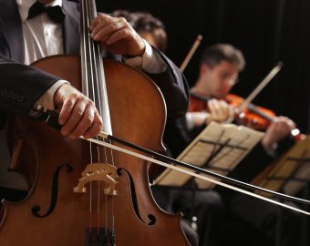Symphony concert, a man playing the cello, hand close up
